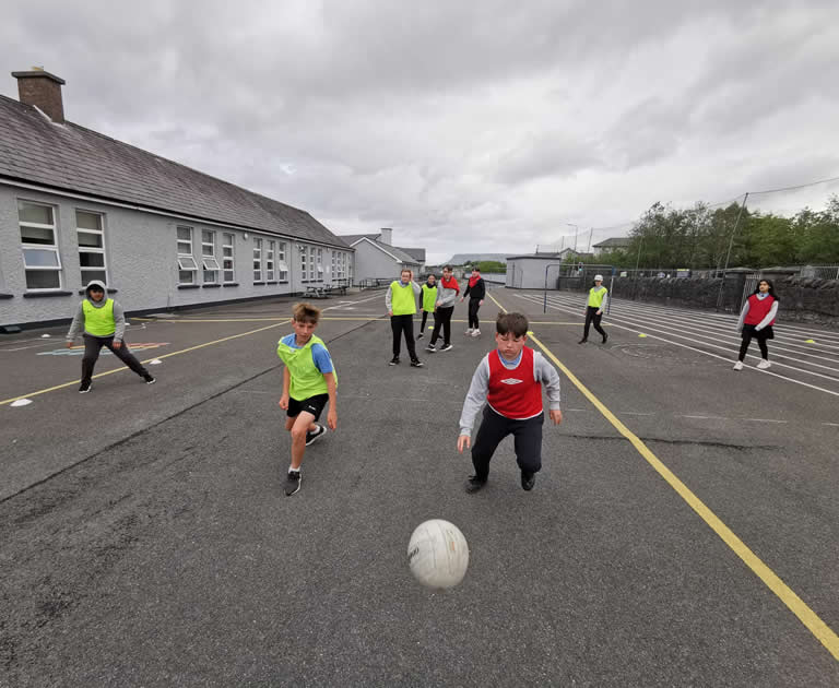 Boys playing football in playground at Our Lady Of Mercy Primary School Sligo