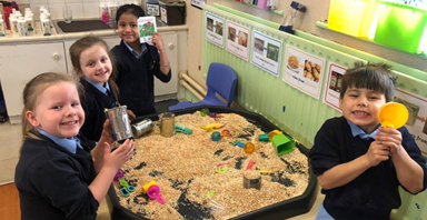 Pupils playing with sand at Our Lady Of Mercy Primary School