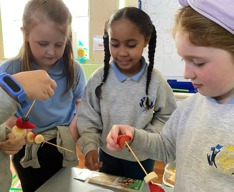 Girls from Our Lady Of Mercy Primary School with fruit sticks