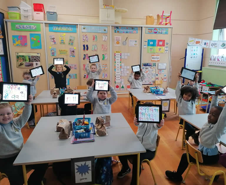pupils holding up laptops at Our Lady Of Mercy Primary School Sligo